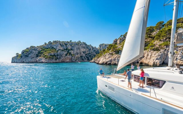 Catamaran naviguant dans les eaux turquoise de la Côte Bleue avec des passagers à bord.